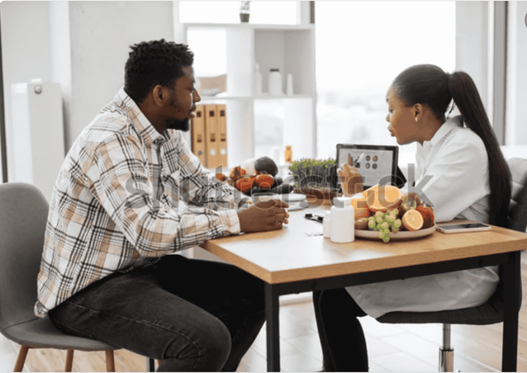 Healthcare professional consulting patient about nutrition at desk.